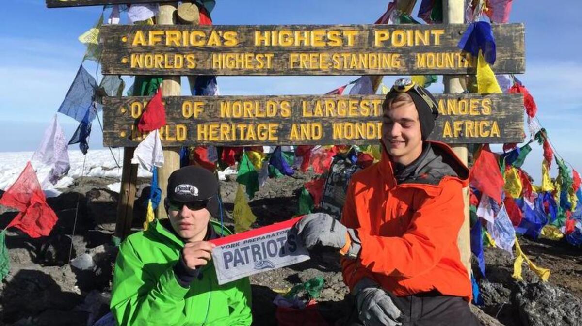 Carter Craze, left, and Jared Johansen display a homemade York Preparatory Academy flag at Uhuru Peak, the summit of Mount Kilimanjaro.