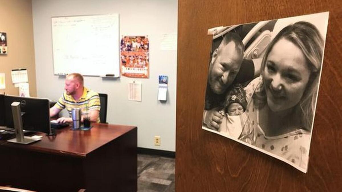 Jeff Fulton works in his office on June 30. A photo of him, his wife and their newborn son is proudly hung on the front of his door.