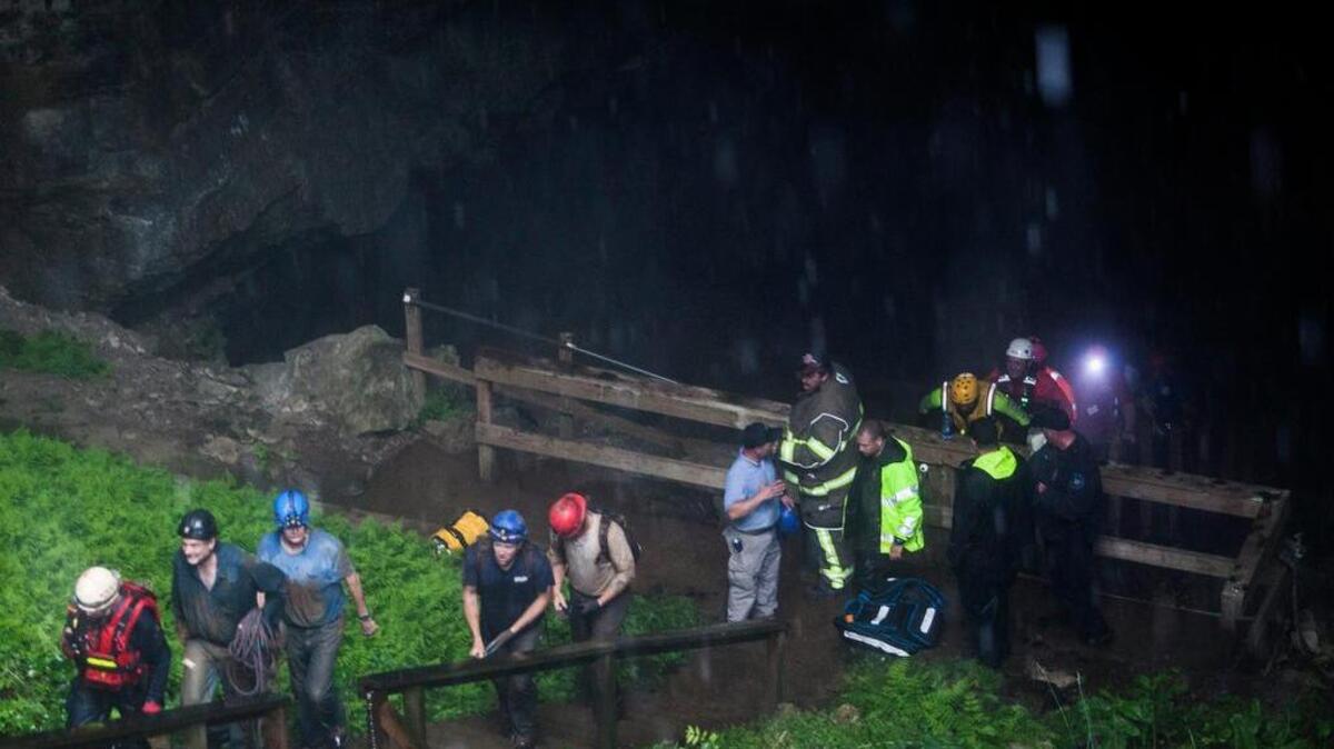 Rescued people walk out of the entrance to Hidden River Cave on Thursday, May 26, 2106, after 18 people on a cave tour were trapped due to flash flood waters in Horse Cave, Kentucky.