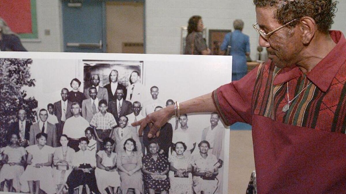 In this 2002 photo, Harry Briggs Jr. points to his father in a 1949 group photo of those who signed the petition that led to desegregation of public school.