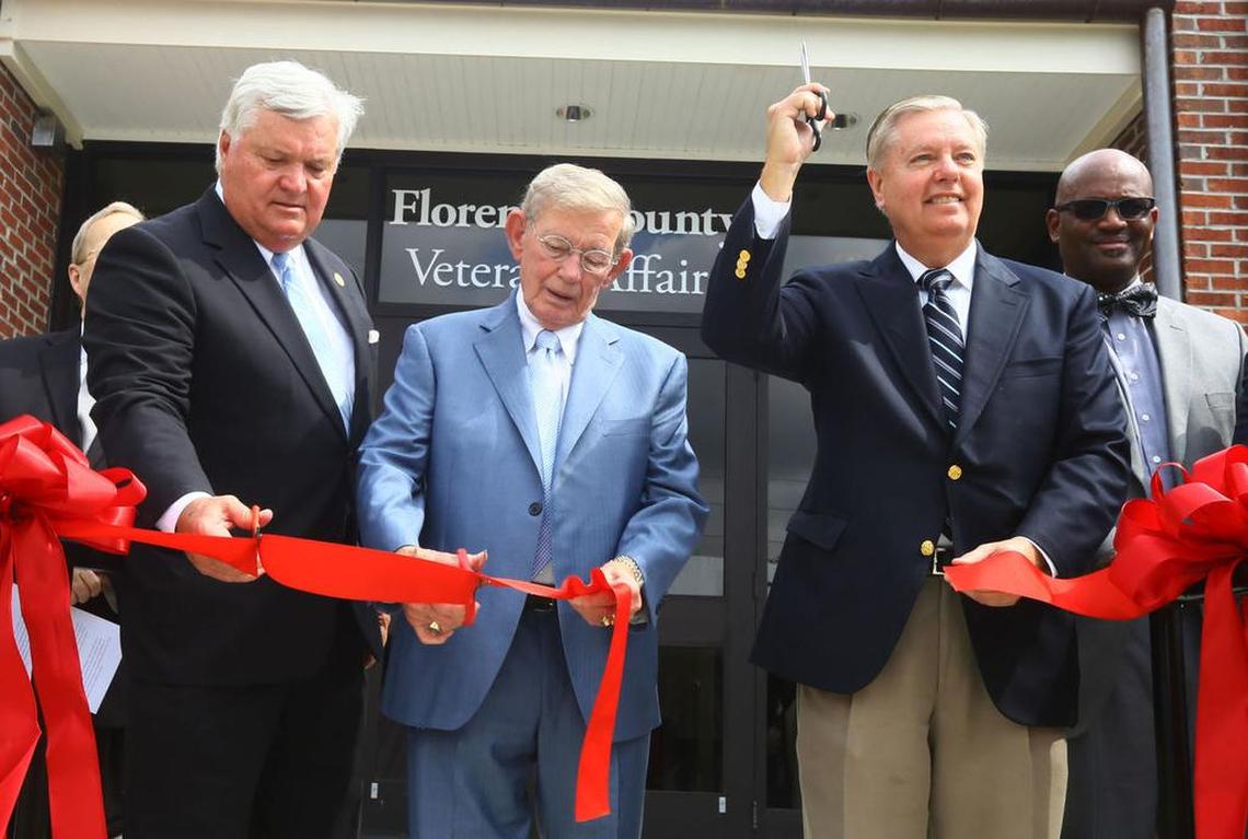 Florence County Council Chairman Kent Caudle (left), S.C. Senate President Pro-tempore Hugh K. Leatherman Sr. (center) and U.S. Sen. Lindsey Graham cut the ribbon during the grand opening ceremony of Florence County’s new V.A. Administration building on National Cemetery Road Monday.