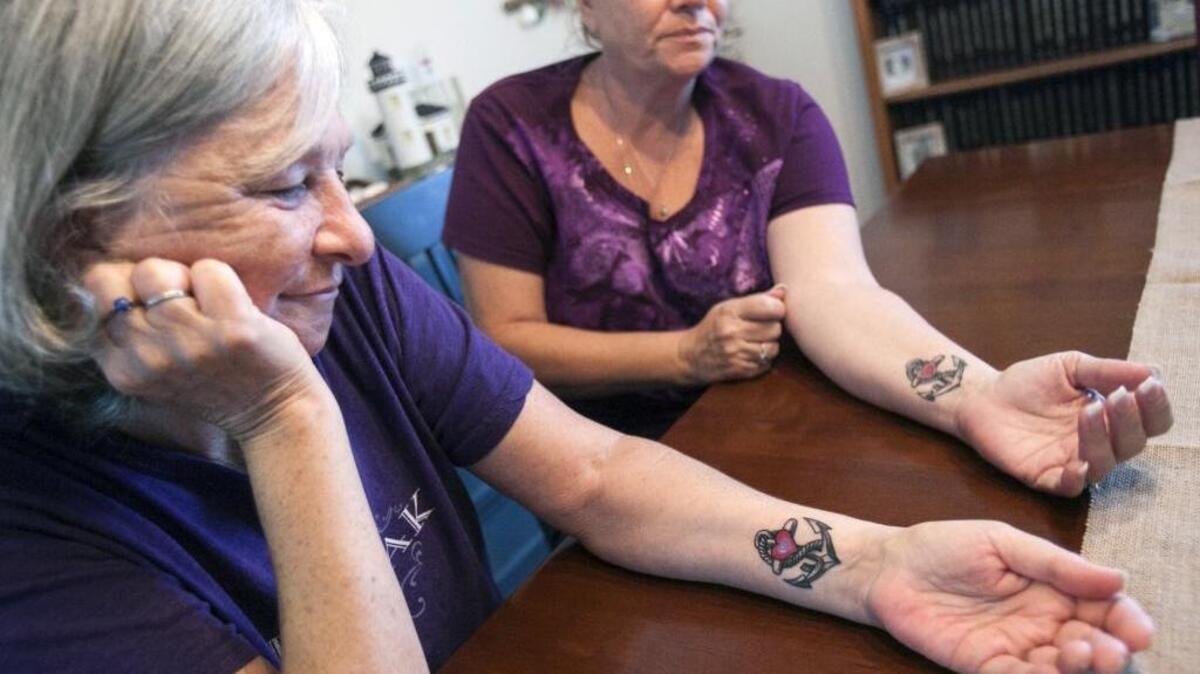 Shelly Wells (left) and Michele Gagne, show matching tattoos they got in memory of their mother Frances "Mae" Davis. The anchor is in memory of their father, who served in the Navy. The heart on the anchor is purple and red for their mother, who loved the color purple. Davis, 78-years-old was shot and killed while sitting in her car a few minutes after noon in front of J.C. Penney at Myrtle Beach Mall on Friday, Jan. 8, 2016. Shelly Wells returned from shopping to find her mother slumped over.