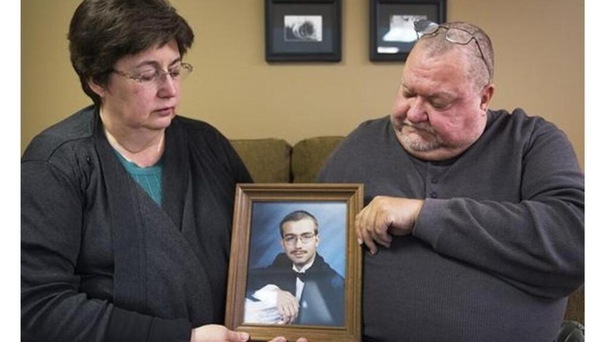 Joanne and Jaye Shiflet, mother and stepfather of Charles David Carver, hold his senior picture on Monday, November 14, 2016.