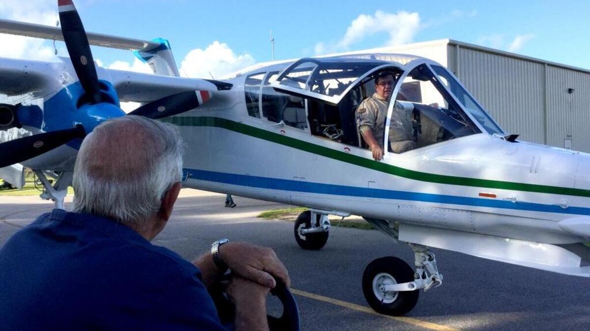 Beaufort County Mosquito Control’s chief pilot, Russ Appleton, climbs sits in the cockpit of the agency’s OV-10 Bronco on Friday, August 12, 2016, at the Beaufort County Airport as mechanic Gary Davy looks on.