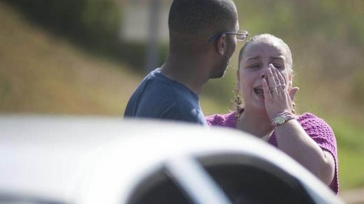 A woman reacts at the scene of a shooting at Southside High School Friday.