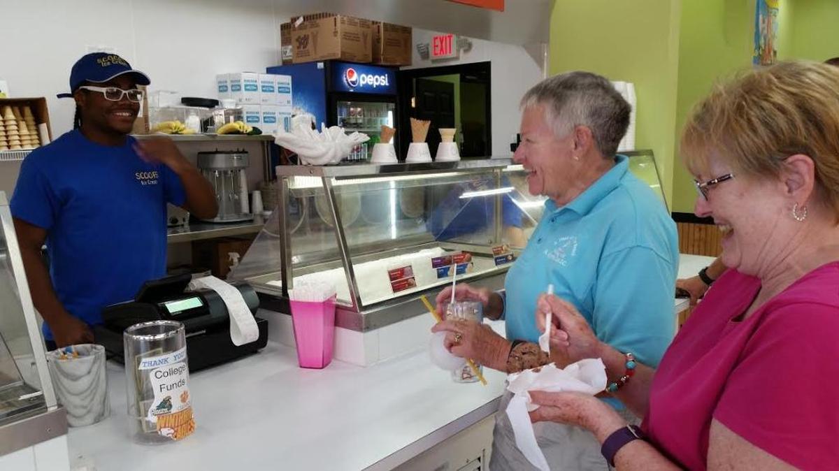Myrtle Beach High graduate and incoming freshman at Winthrop University Jay Trappier shares a laugh Thursday evening with vacationing Winthrop alumnae Betty Creamer (center) and Bonnie Farmer. The women and two friends began “stuffing the tip jar” at Scoops Ice Cream in Windy Hill after realizing Trappier plans to attend Winthrop in the fall.