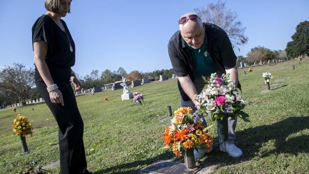 Daved Kinard, a florist and store manager with The Daisy Fair Flowers, along with Meghan Goldfinch Hayden, of Hillcrest Cemetery, places a fresh floral arrangement on baby Grace Carlson Santa Cruz's grave for the anniversary of her death. Kinard changes flowers on the graves of both "Baby Grace," and "Baby Boy Horry," every season.