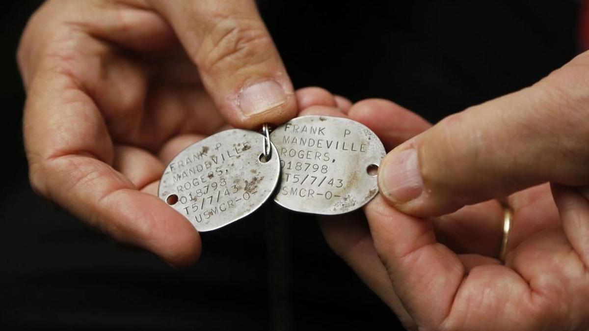 Frank "buzz" Rogers holds dog tags that belonged to his late father and were found on a Florida beach following Hurricane Matthew.