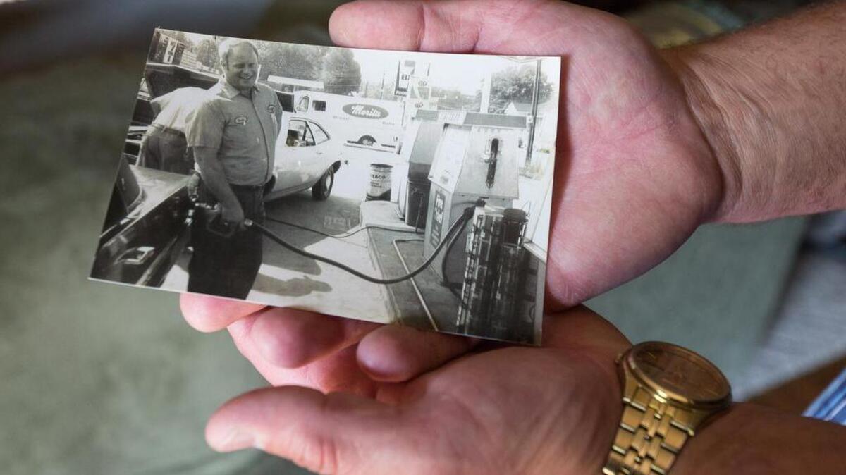 Eddy Evans holds a photo of his father pumping gas at his Texaco station in Fort Mill around 1978.