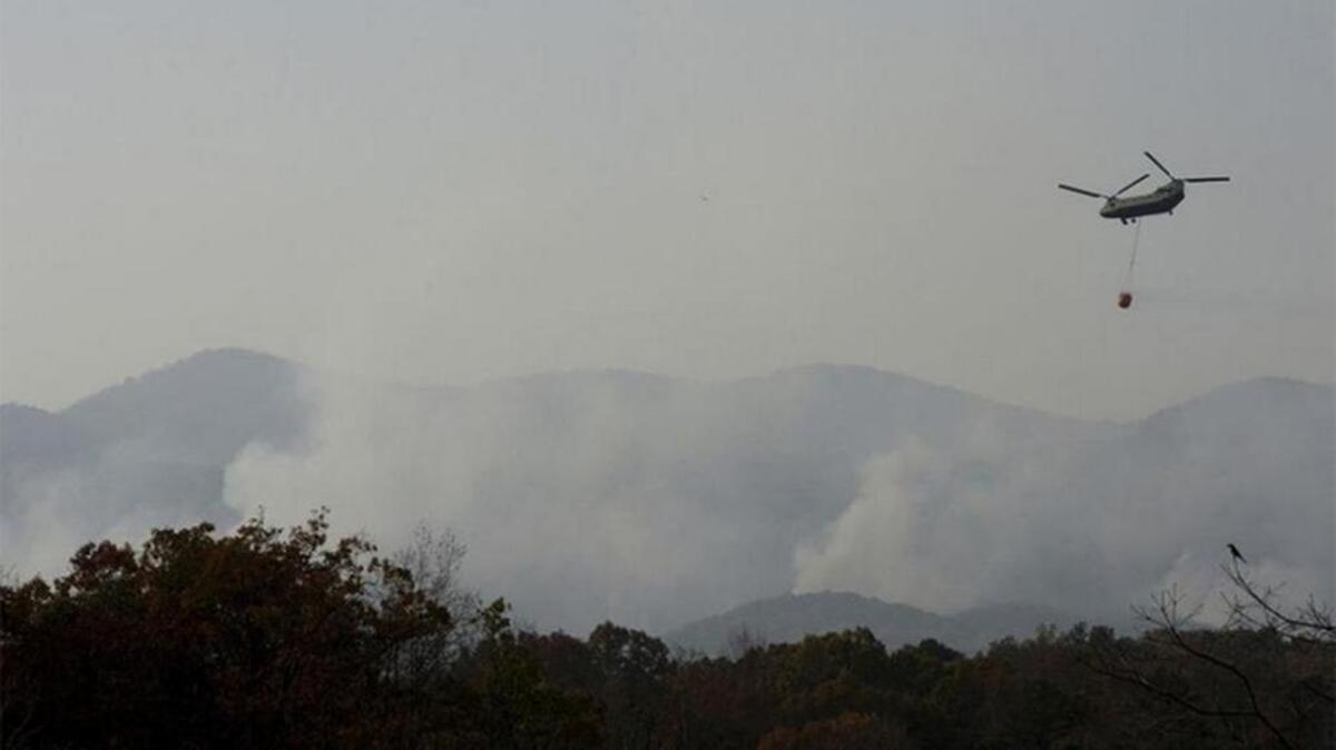 A Chinook helicopter flies over Table Rock State park as fire fighters continue to fight wildfires