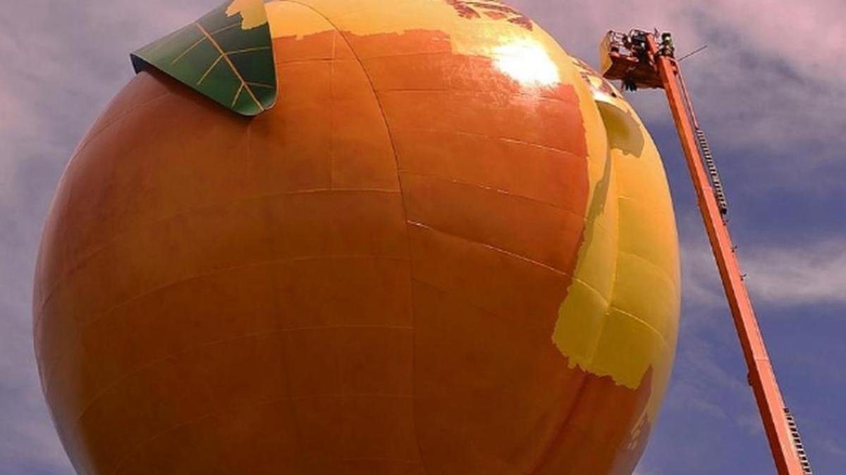 New paint is being applied to the Gaffney Peachoid after the Gaffney Board of Public Works decided the paint job from two years ago didn't look enough like a real peach.