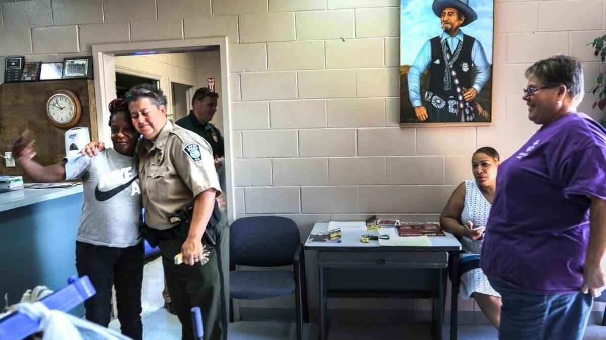 FILE PHOTO (May 2015) Latta Police Chief Crystal Moore hugs Wanda Braxton in the Latta Police office. Moore was fired by the mayor because of her sexuality. The town rallied behind her and voted to change the town's form of government from a strong-mayor to strong-council. The council reinstated Moore in 2014.