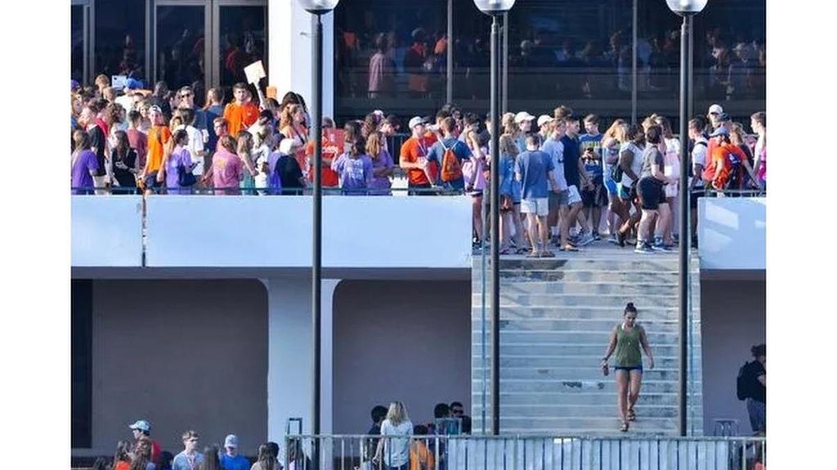 Clemson University new students gather for orientation in groups on the bridge while other walk by, outside the Cooper Library in Clemson on Monday.