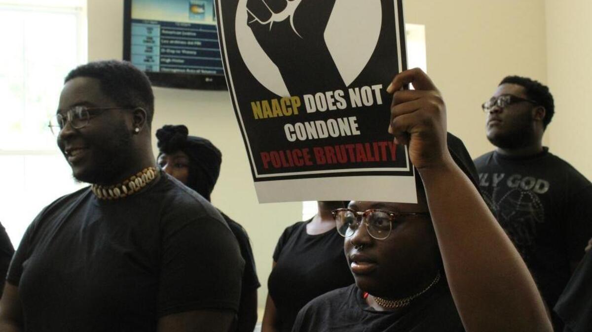 Students in Hicks Dining Hall at Coastal Carolina University hold signs during a protest against police brutality.