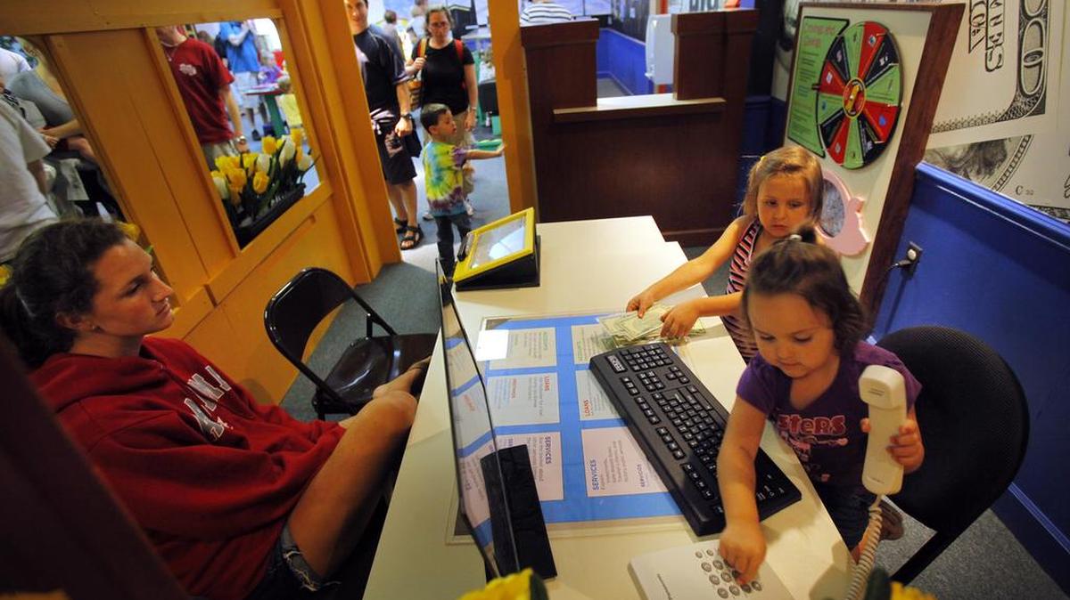 Family members play in a “Big Bank” exhibit at the Children’s Museum of South Carolina, in Myrtle Beach. On March 1, the site will merge operations with EdVenture, a children’s museum in Columbia.