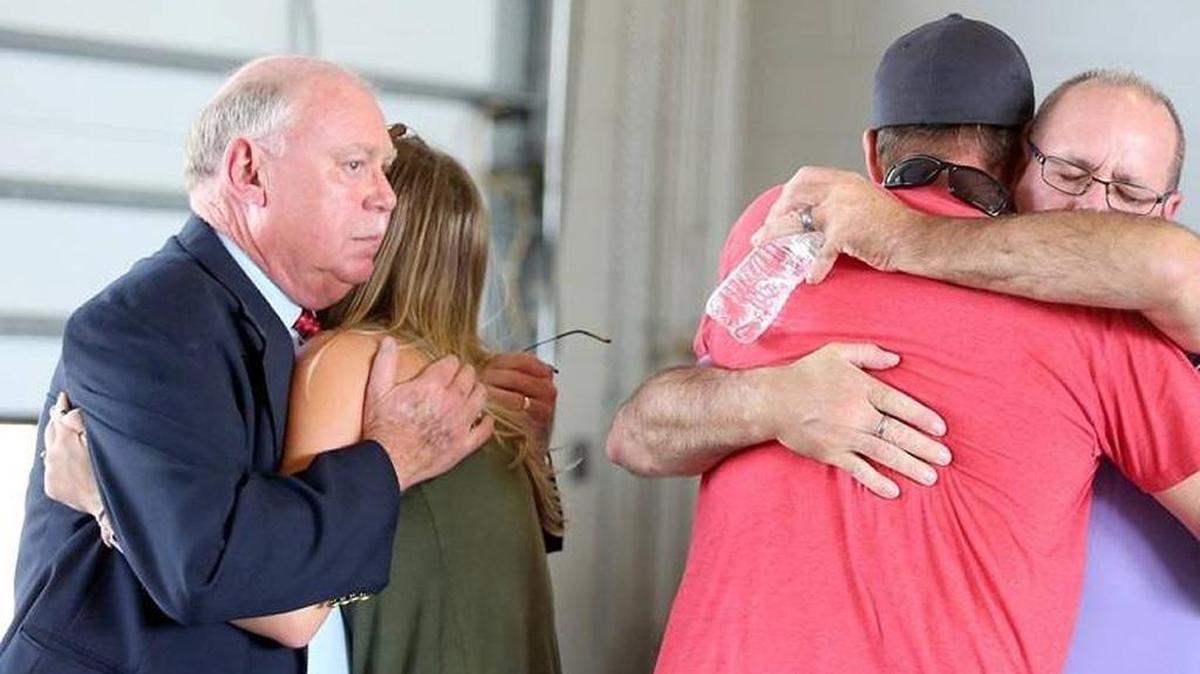 Family and friends are embraced by law enforcement after the announcement of the arrest of a man charged with killing two women at the CresCom Bank off 16th Avenue in Conway. Aug. 23, 2017