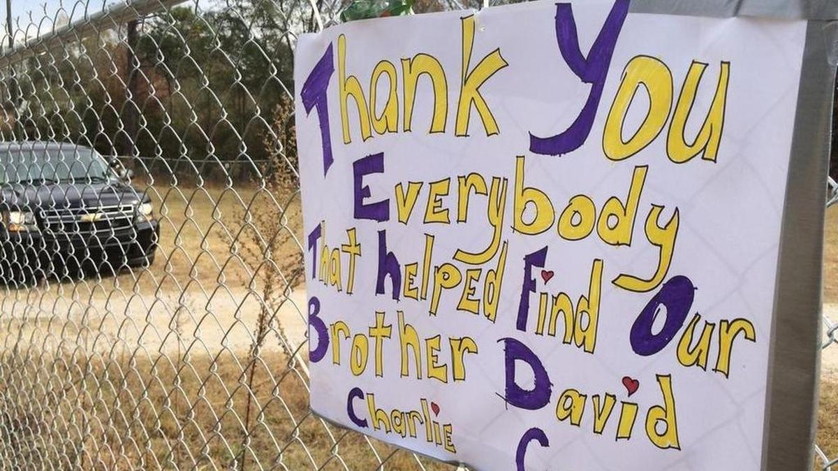 Signs were left along a fence surrounding the suspect’s Woodruff area property, where investigators worked Tuesday.