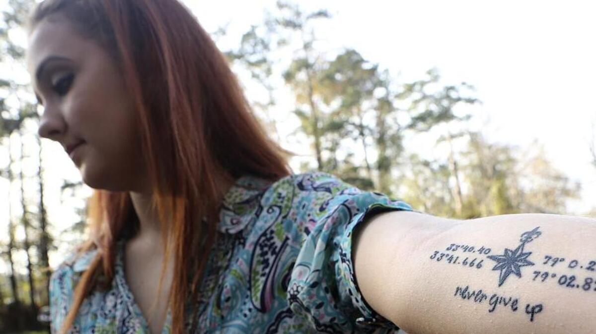 "The bottom quote of 'Never give up' is her handwriting from the last note she ever gave me," Morgan Elvis says of the tattoo on her left arm. She talks about her sister Heather Elvis, plans for the second memorial vigil and that tattoo at Peachtree Landing on Saturday, Dec. 12, 215. The top coordinates are the family home and the bottom coordinates are the landing where Heather's car was found. The compass is a colorless version of the one on Heather's wrist. And, Morgan says, the longest point in the compass follows the line of the vein that leads to her heart. The quote is from Harriet Beecher Stowe. "When you get into a tight place and everything goes against you until it seems that you cannot hold on for a minute longer, never give up then, for that is just the place and time when the tide will turn," Morgan recounted the more than a dozen times her sister left her notes with that quote to lift her up in tough times. Heather Elvis, 20 at the time, was reported missing Dec. 19, 2013, after her car was found at Peachtree Landing in the Socastee community. The vigil is slated for 5 p.m. Saturday, Dec. 18, 2015, at the landing.