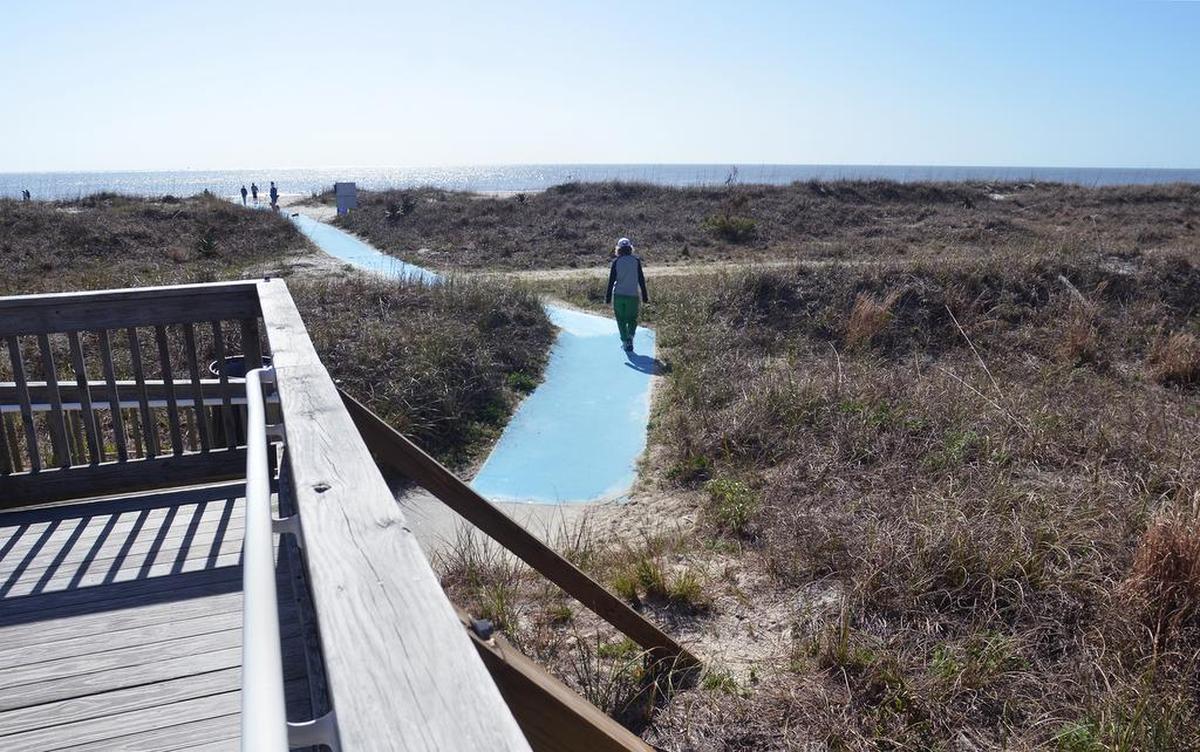 A beachgoer walks the path to the beach at Hilton Head Island’s Islanders Beach Park in 2017.