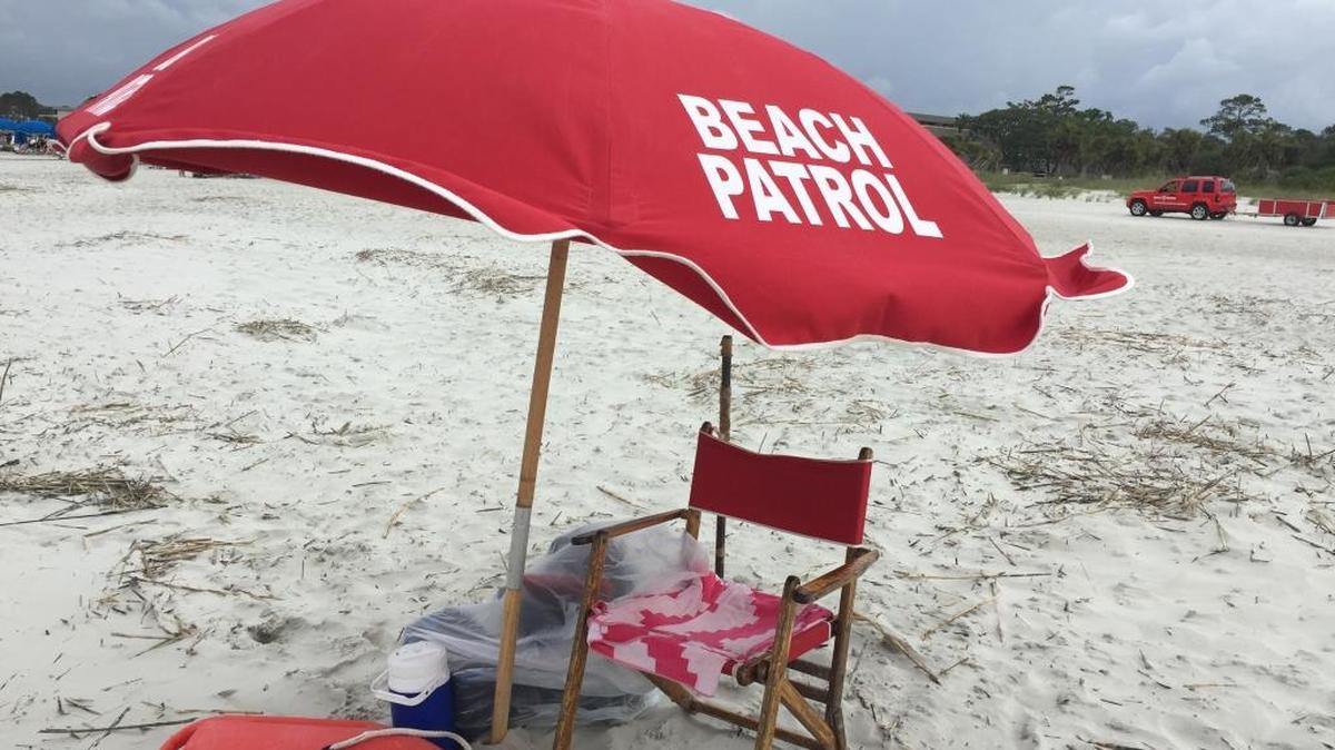 A beach patrol stand at Coligny Beach on May 23, 2017, sits empty while lifeguard Maddy Yemc helped visitors close beach umbrellas before a storm. Beach patrol workers are stationed throughout Hilton Head beaches to assist with rental equipment.
