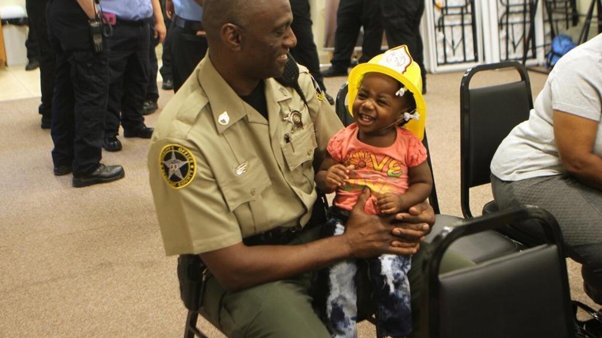 Isaac Fripp, of St. Helena Island, holds his 1-year-old granddaughter Treasure Jefferson on July 25, 2016, before a ceremony at the Lady's Island-St Helena Fire District Station 24 to honor the first responders who helped to save her life when she nearly drowned in a family pool on July 7. Fripp administered CPR to his granddaughter before the first responders arrived, helping to save her life.