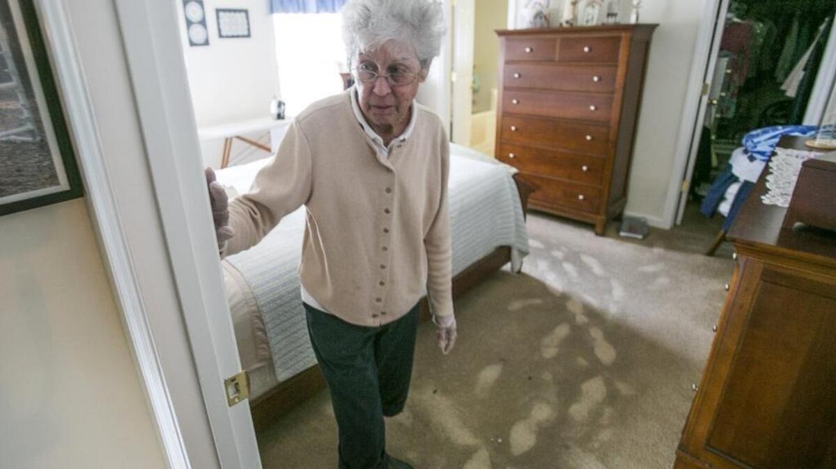 
Betty Skeen, a seven-year resident of the Sand Ridge community, looks at her water-damaged home leaving tracks on wet carpet.
