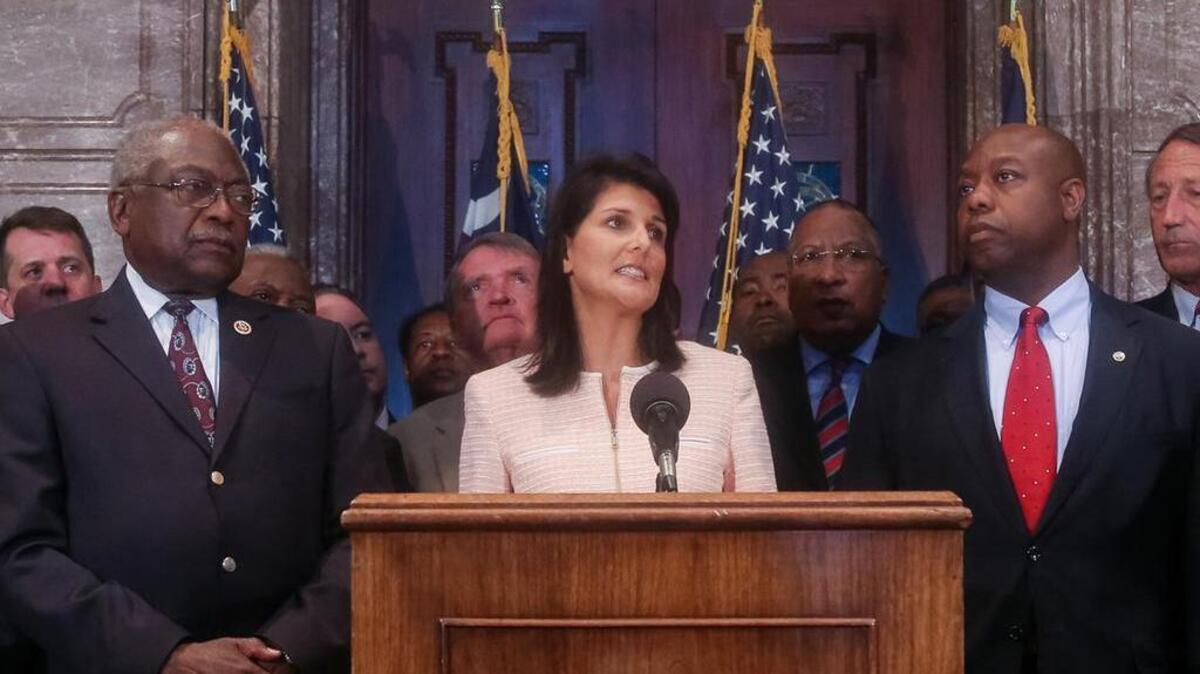 South Carolina Gov. Nikki Haley speaks during a news conference in the South Carolina State House, Monday, June 22, 2015, in Columbia, S.C. Haley said that the Confederate flag should come down from the grounds of the state capitol, reversing her position on the divisive symbol amid growing calls for it to be removed. Also pictured are U.S. Congressman James Clyburn, left, and U.S. Sen. Tim Scott, right. (Tim Dominick/The State via AP)