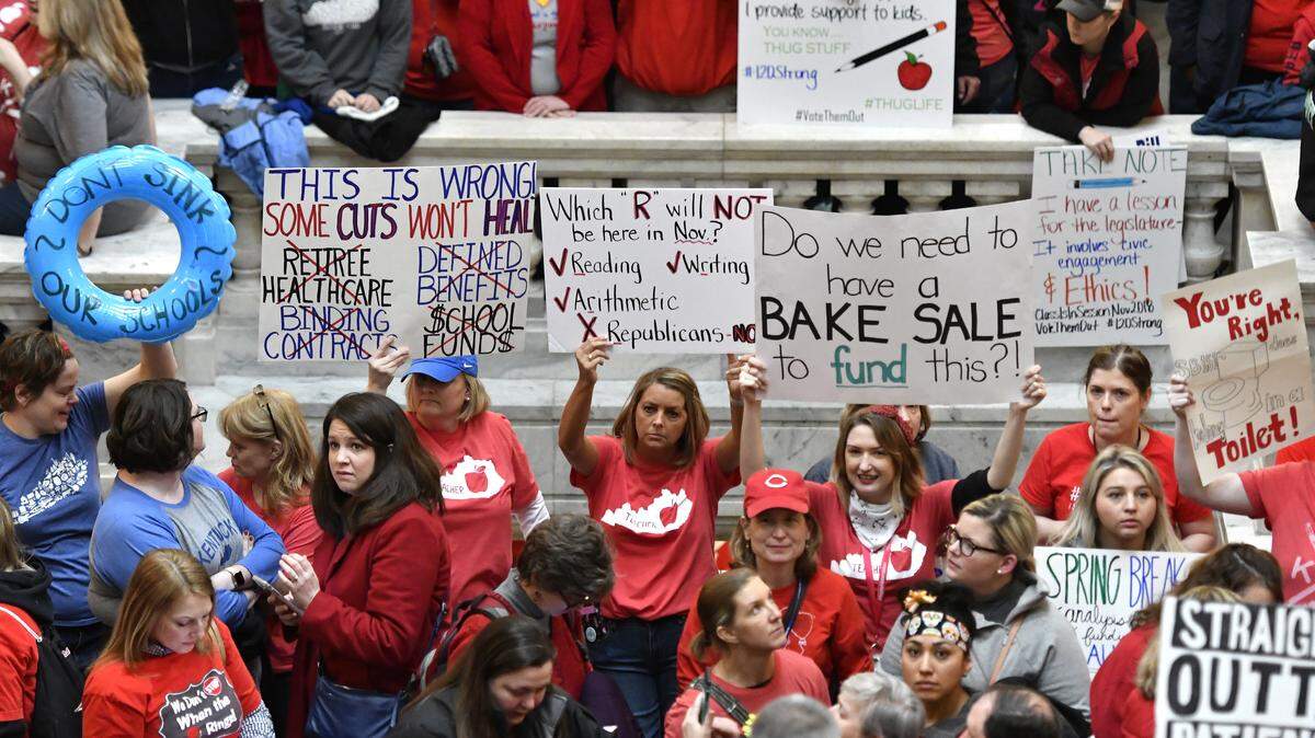 Teachers from across Kentucky hold up signs as they fill the state Capitol to rally for increased funding and to protest last minute changes to their state funded pension system, Monday, April 2, 2018, in Frankfort, Ky.