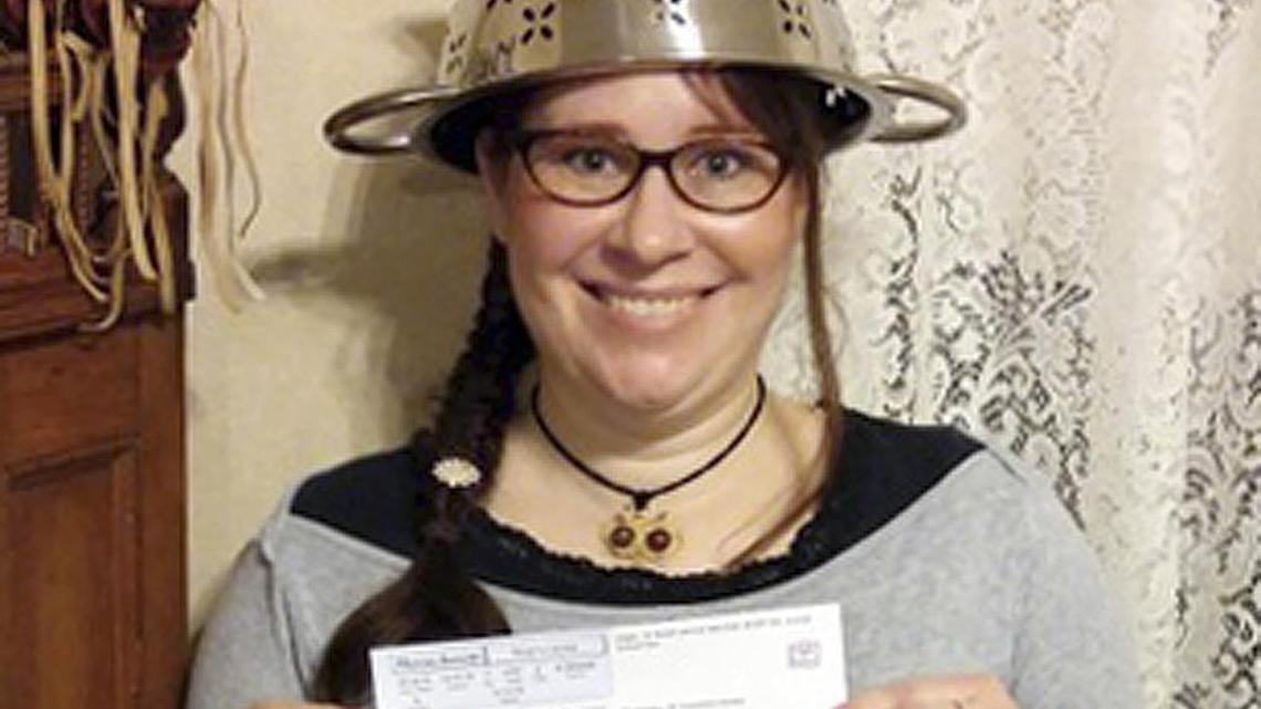 In this Nov. 12, 2015 photo provided by Darrick Fauvel, Lindsay Miller of Lowell, Mass., wears a spaghetti strainer to reflect her religious beliefs while holding her temporary driver license that also bears a photo of her wearing the colander. Miller said she “absolutely loves the history and the story” of Pastafarians, who are part of the Church of the Flying Spaghetti Monster. The Massachusetts Registry of Motor Vehicles initially forbade Miller to wear the colander in the identification photo. She said the agency reversed the decision and apologized.