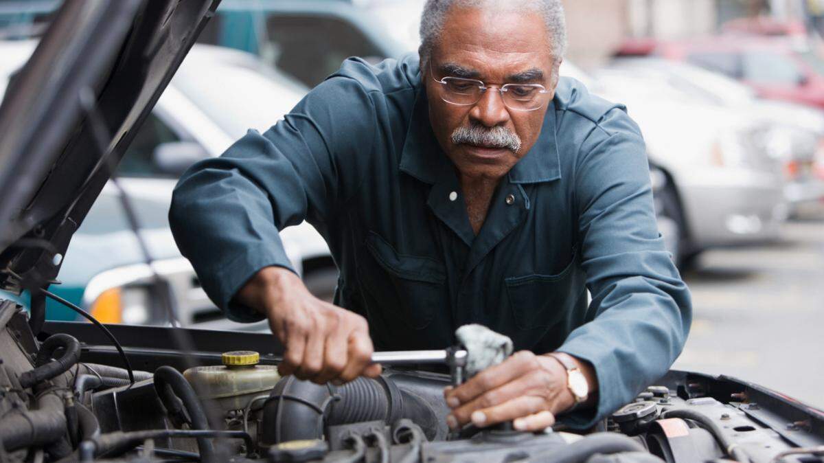 African American man working on car - stock photo