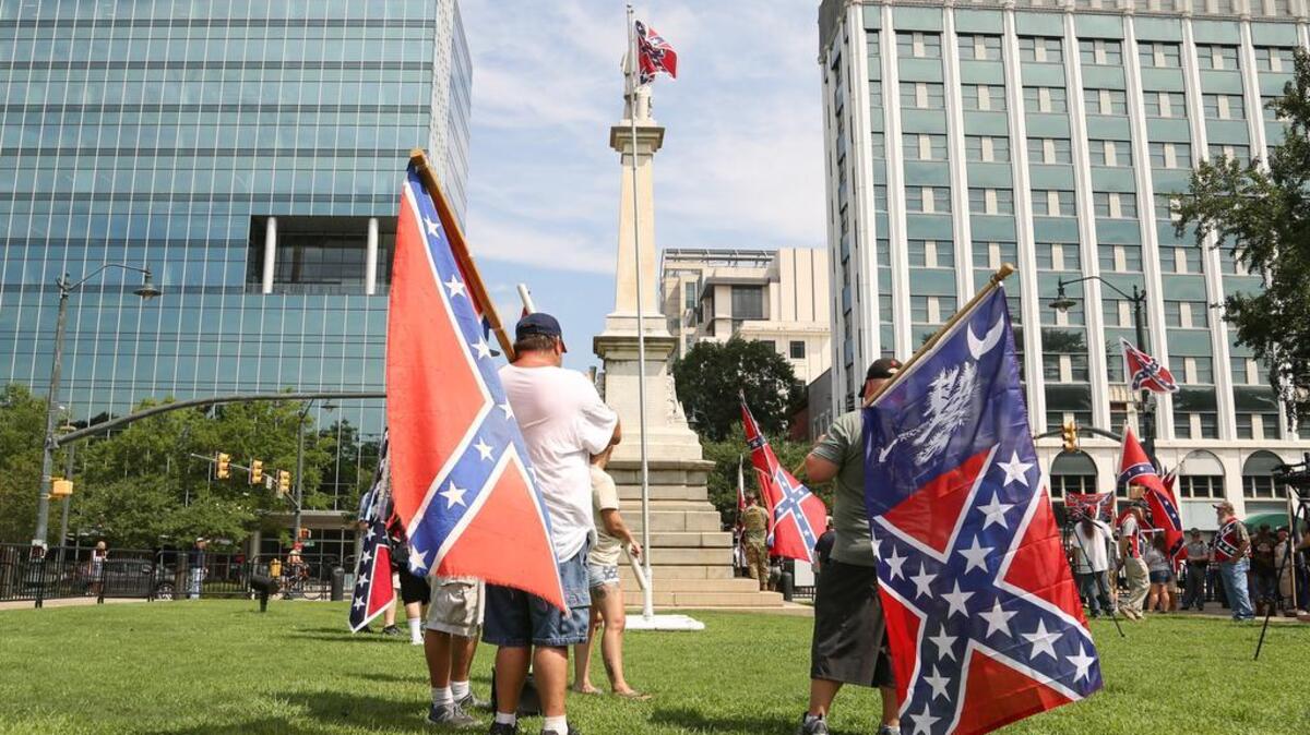 SC Secessionist Party members wave Confederate flags at a State House rally this month to mark the second anniversary of the flag’s removal from the grounds.