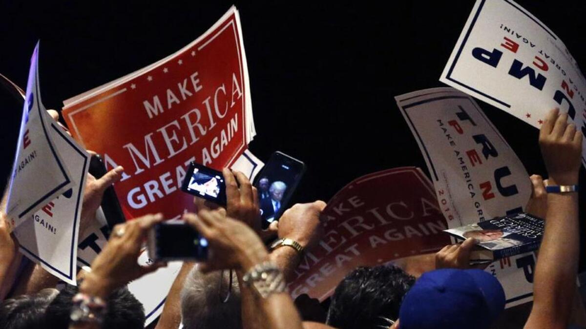 Supporters wave their signs toward Republican presidential candidate Donald Trump.
