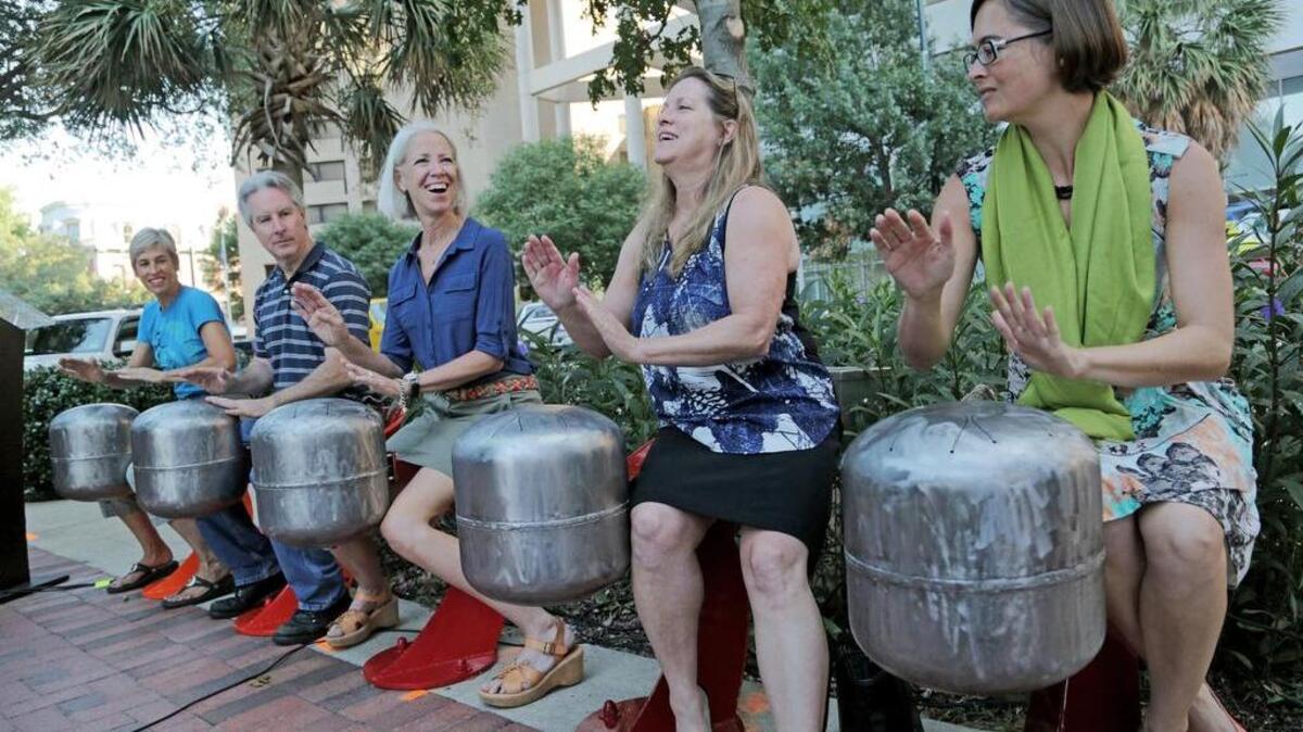 Artists Mark Finley, second from left, and Eileen Blythe join as One Columbia unveils their interactive musical sculpture on Main Street. Questions have been raised about how One Columbia is financed and how it spends public funds.