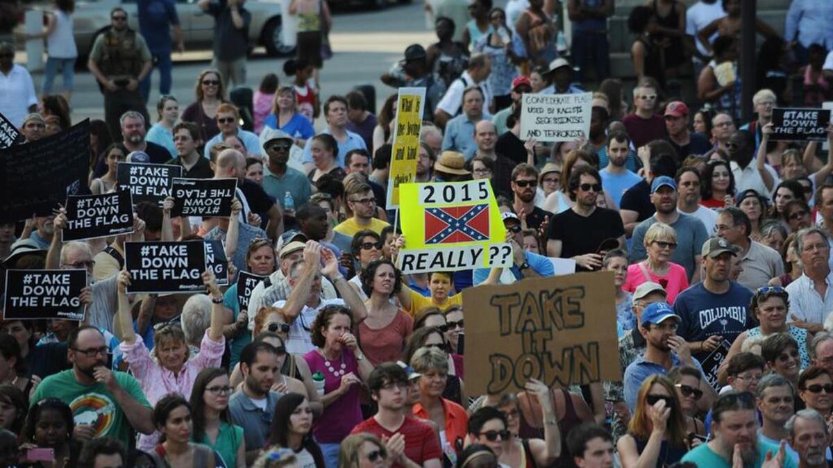 
Protesters holds signs during a June rally to take down the Confederate flag at the SC State House.
