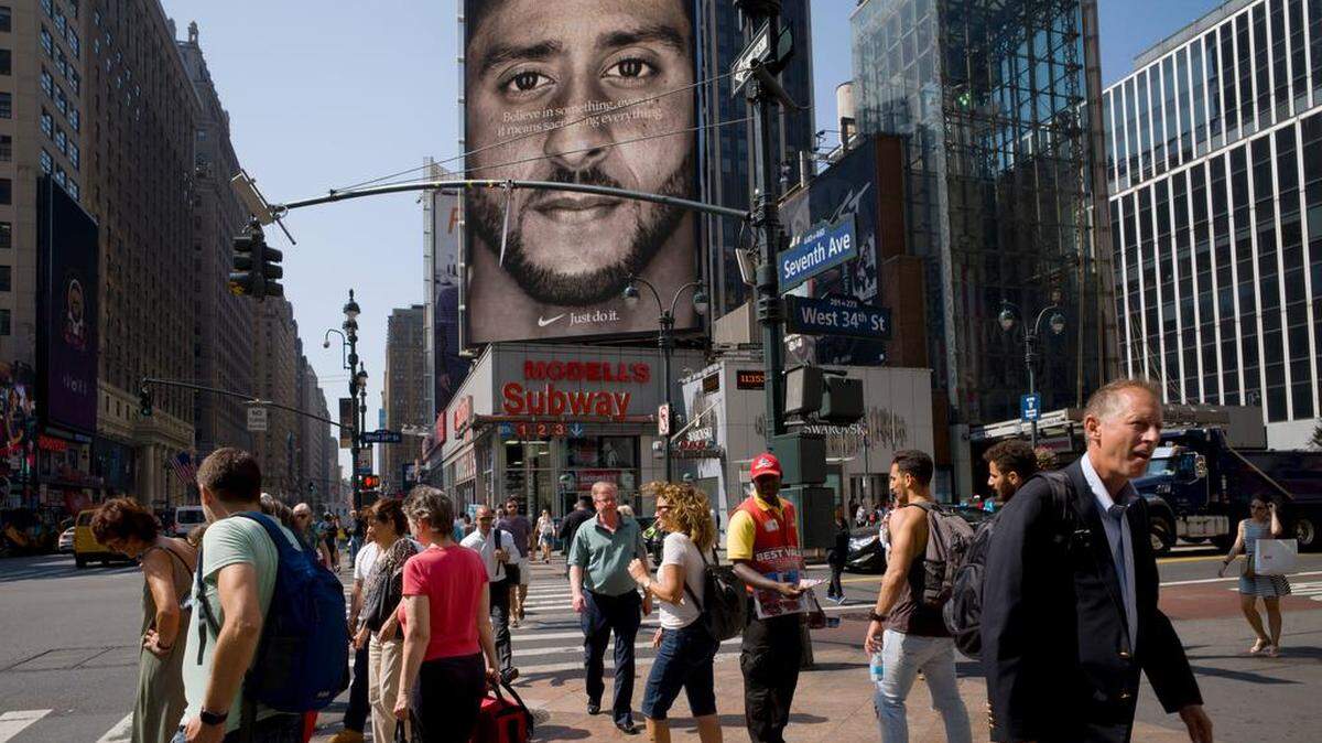 People walk by a Nike advertisement featuring Colin Kaepernick on display last week in New York. Nike last week unveiled the deal with the former San Francisco 49ers quarterback, who’s known for starting protests among NFL players over police brutality and racial inequality.