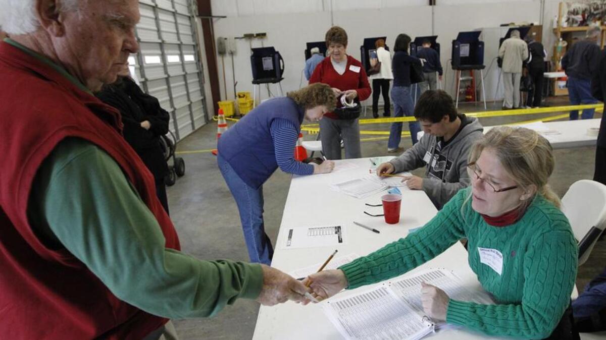 A poll manager checks IDs at the Amicks Ferry Fire Station in Chapin.