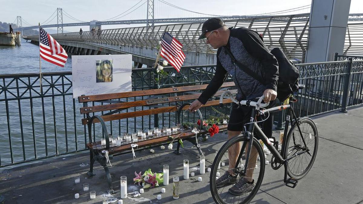 Craig Warner of Palo Alto, Calif., leaves a bell at a memorial site for Kate Steinle on Pier 14 in San Francisco on Friday. In this fiercely liberal city, city leaders remained attached to their sanctuary city status despite a not-guilty verdict in a killing that sparked feverish immigration debates because the man who fired the gun was in the country illegally after being deported five times.