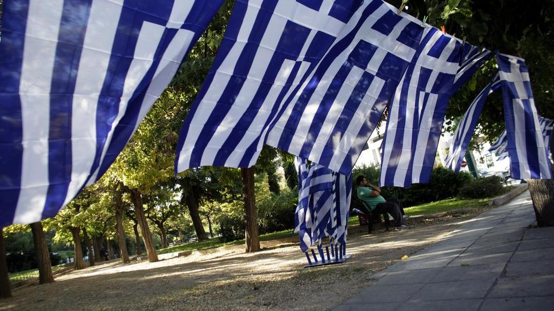 Greeks place national flags at their balconies to commemorate Greece’s entry in World War II in Oct. 28, 1940.