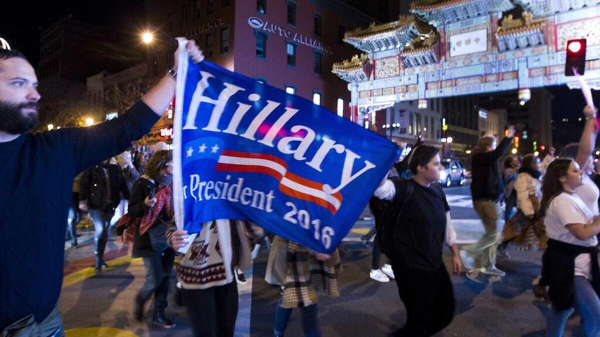 A protester holds a banner supporting Hillary Clinton during a march in downtown Washington in opposition to Donald Trump’s election.