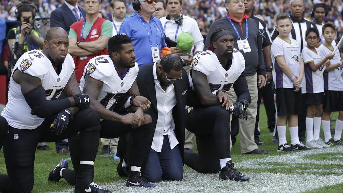 Baltimore Ravens outside linebacker Terrell Suggs, from left, Mike Wallace, former player Ray Lewis and inside linebacker C.J. Mosley kneel during the playing of the national anthem before an NFL football game between the Jacksonville Jaguars and the Ravens at Wembley Stadium in London.