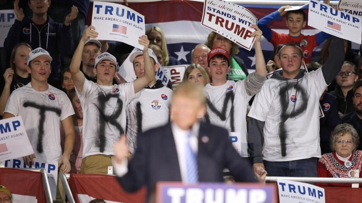 Supporters react as Republican presidential candidate Donald Trump speaks at a campaign rally.