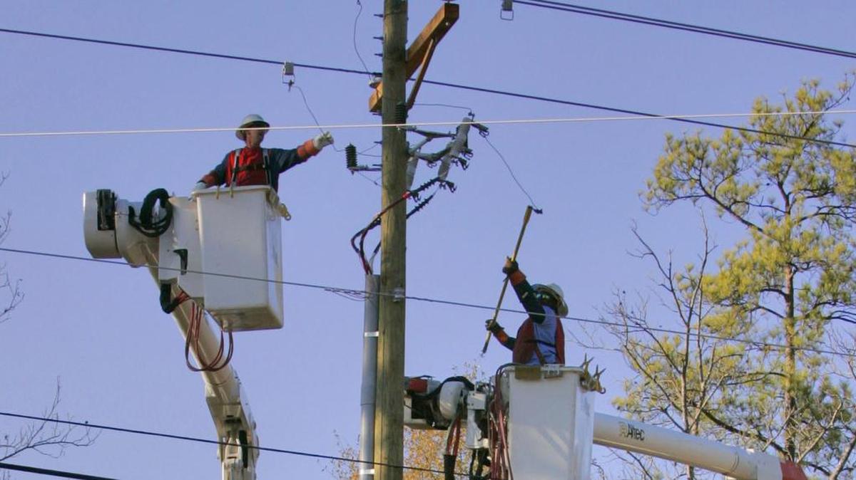Linemen working on an electrical pole in a file image.