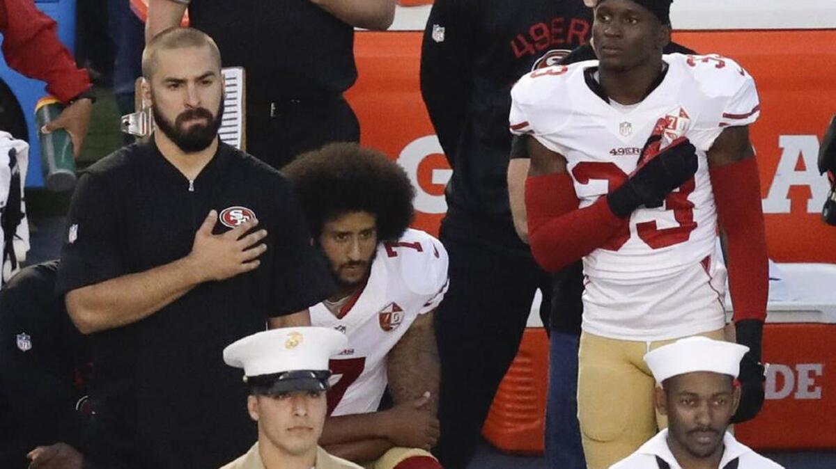 San Francisco 49ers quarterback Colin Kaepernick kneels during the national anthem.