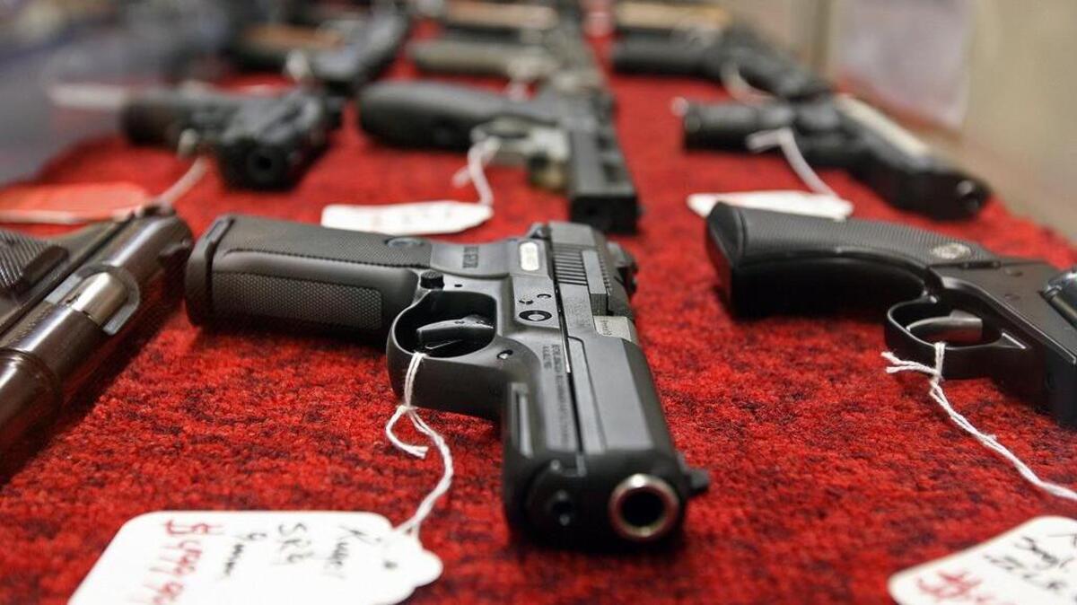 Hand guns line a display case at a Columbia gun store.