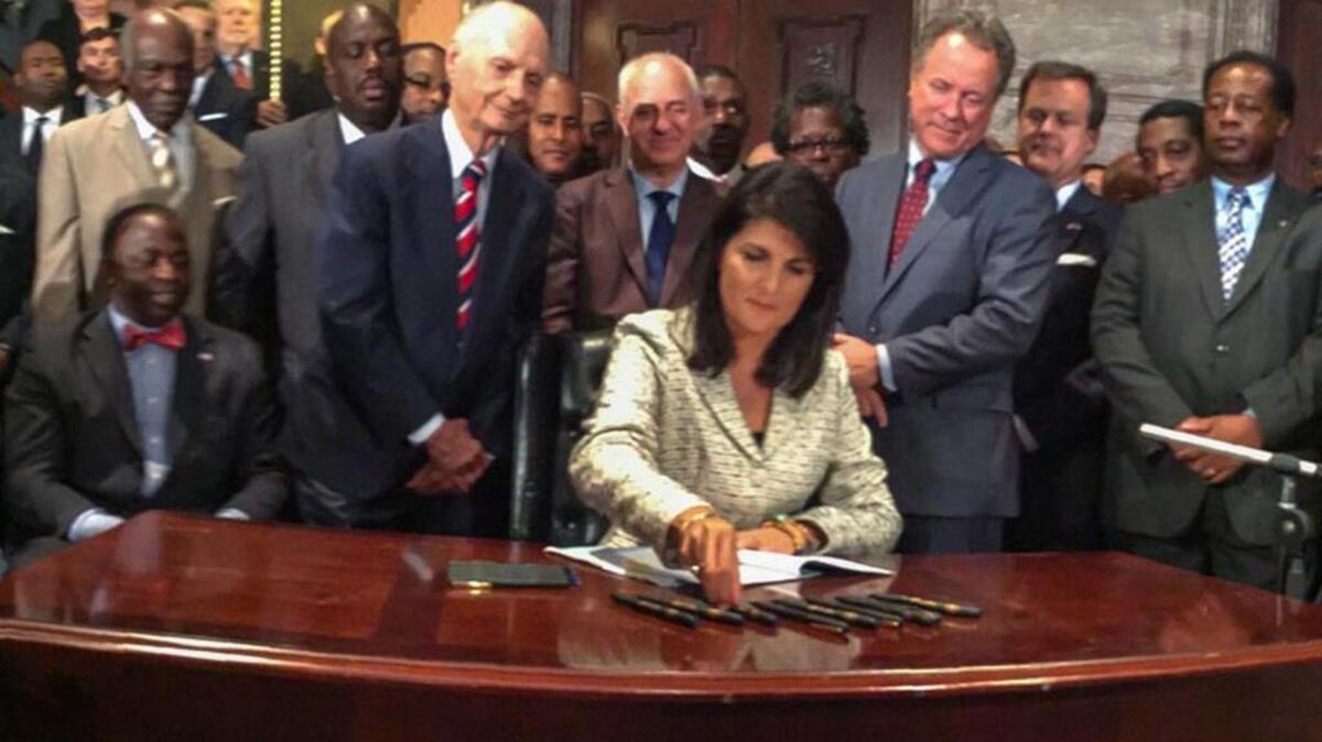 
SC Gov Nikki Haley signs the bill to remove the Confederate battle flag from the State House grounds.
