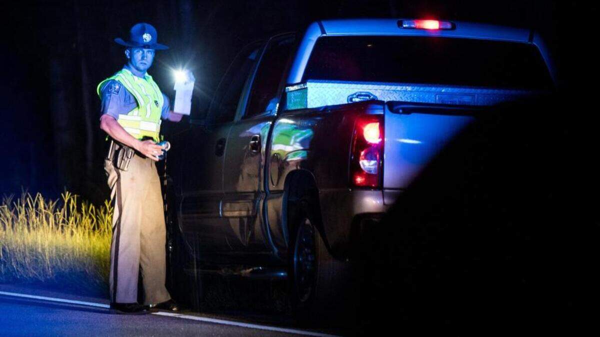A South Carolina state trooper holds an empty can of beer during a traffic stop that resulted in a high-speed chase on Aug. 17 near Camden.