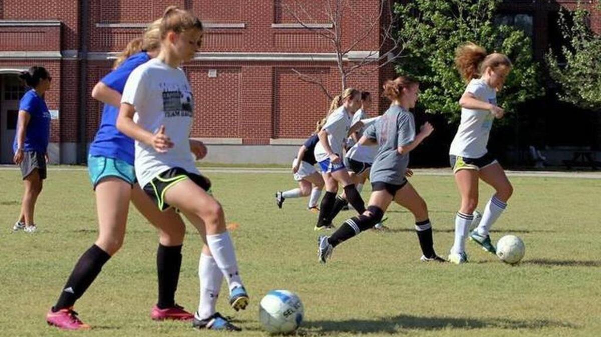 Dreher students play soccer on a crowded field on campus.