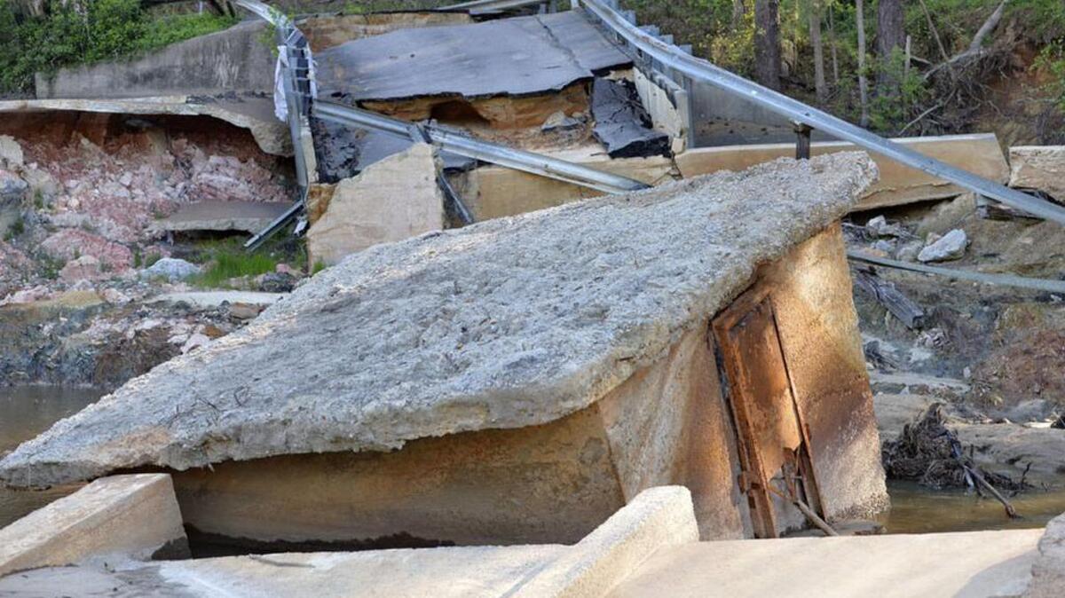 Crumbled remains of the Cary Lake Dam after the 2015 floods topped the dam, eating away at its earthen sides and collapsing the road on top of it.