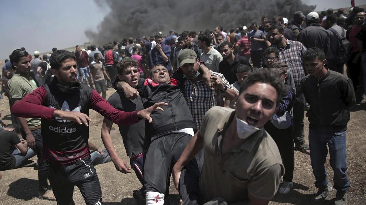 Palestinian protesters carry an injured man who was shot by Israeli troops during a deadly protest at the Gaza Strip’s border with Israel on May 14. Thousands of Palestinians protested near the border as Israel celebrated the inauguration of a new U.S. Embassy in contested Jerusalem.