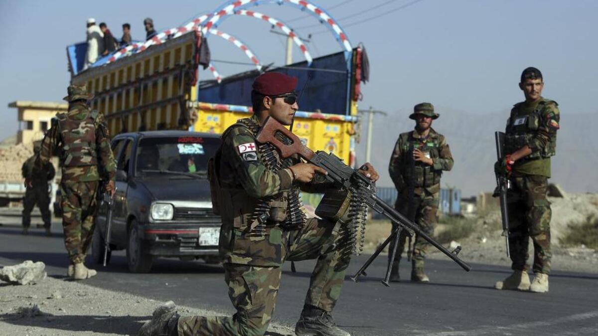 Afghan national army soldiers stand guard at a checkpoint on the outskirts of Kabul, Afghanistan.